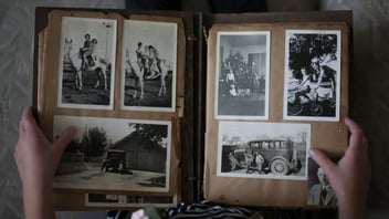 a person opening an old photo album of family memories