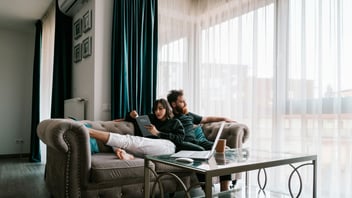 Couple relaxing together on a couch at home in a bright living room