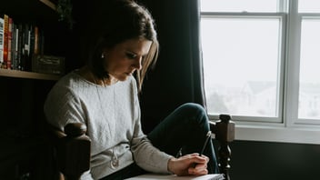 Woman reflecting and writing in a notebook