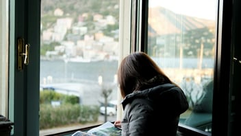 Woman thinking quietly by a bright window