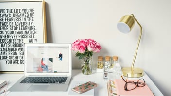 Tidy workstation with laptop, lamp, and notebooks