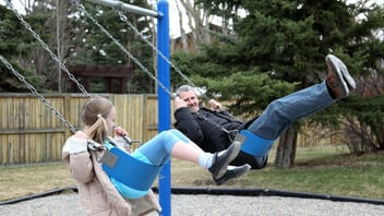 Father and daughter on playground swings