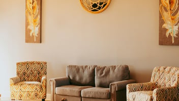 Warm and inviting counseling office sitting room with a couch and armchairs