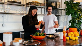 Couple cooking side by side at home