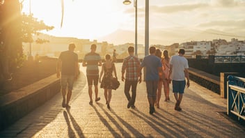 people walking together on sand in warm light