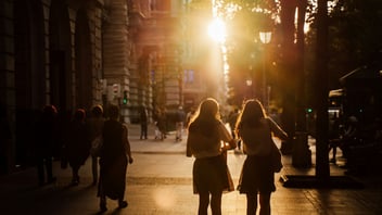 a couple walking through the city together at sunrise