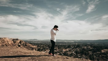 a person standing confidently on a mountain overlook
