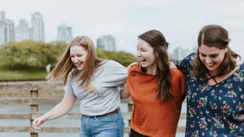 Three teens walking together on a boardwalk