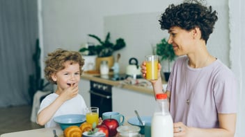 Mother managing the morning breakfast routine with her young son in the kitchen