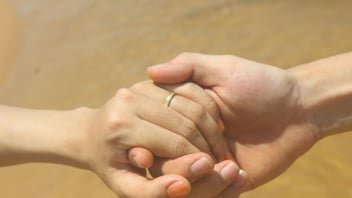 a close up of an engaged couple holding hands