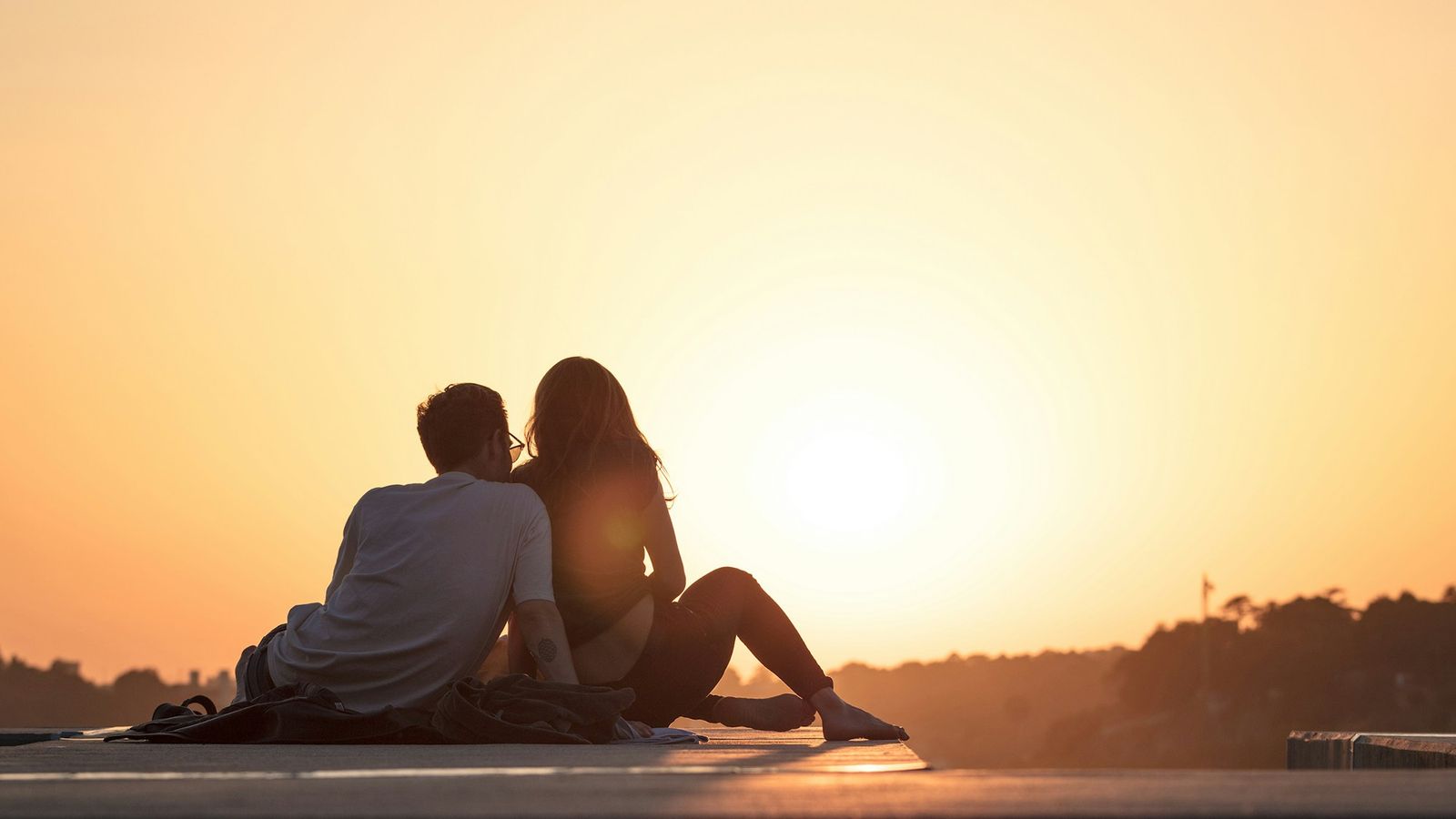 Couple sitting close at golden hour