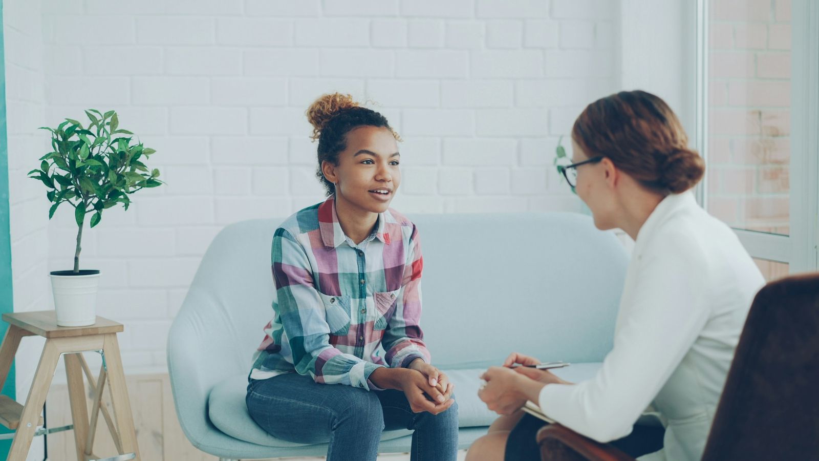 Smiling client talking with her psychologist in a bright studio