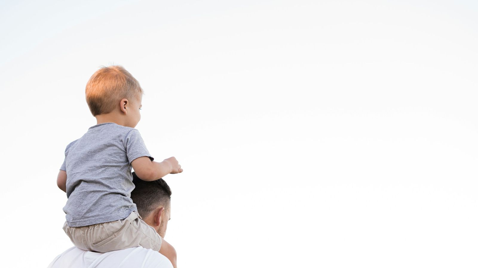 Father carrying his young son outdoors
