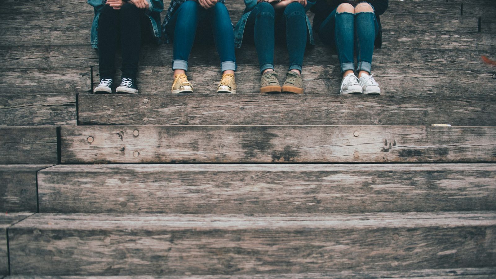 Group of teens hanging out on wooden stairs