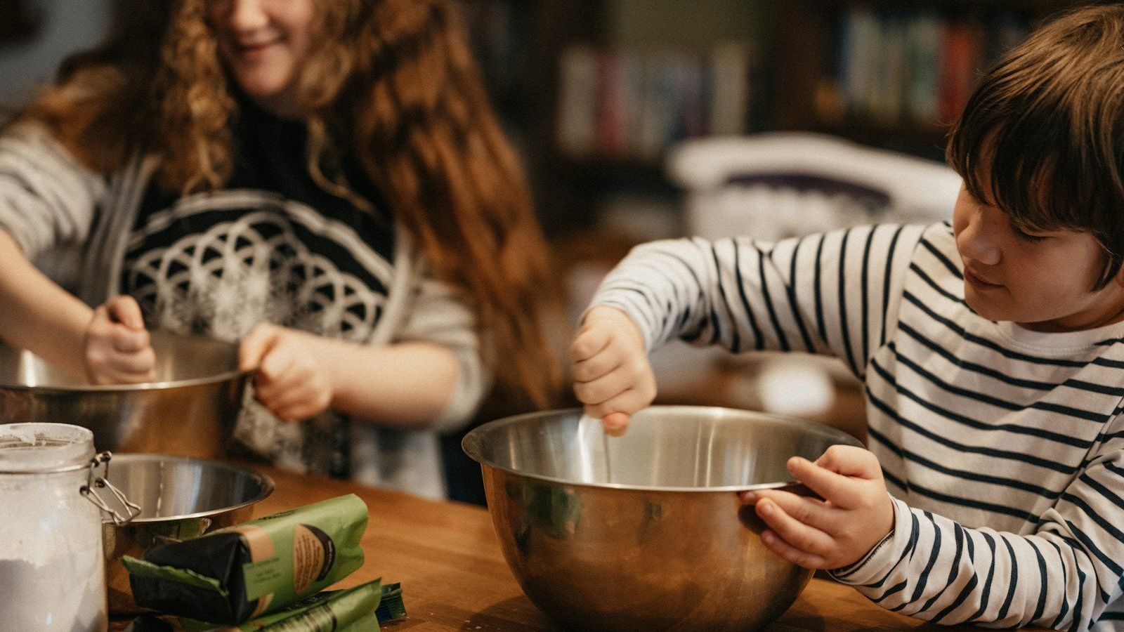 Two kids mix ingredients in bowls while baking together in the kitchen