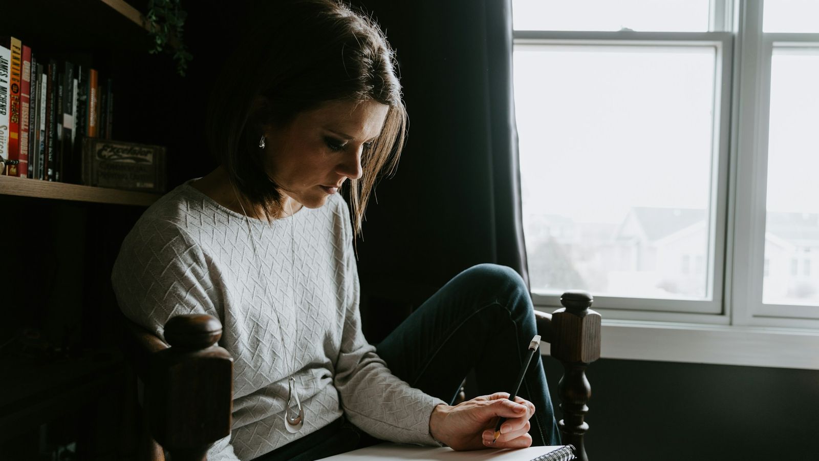 Woman reflecting and writing in a notebook