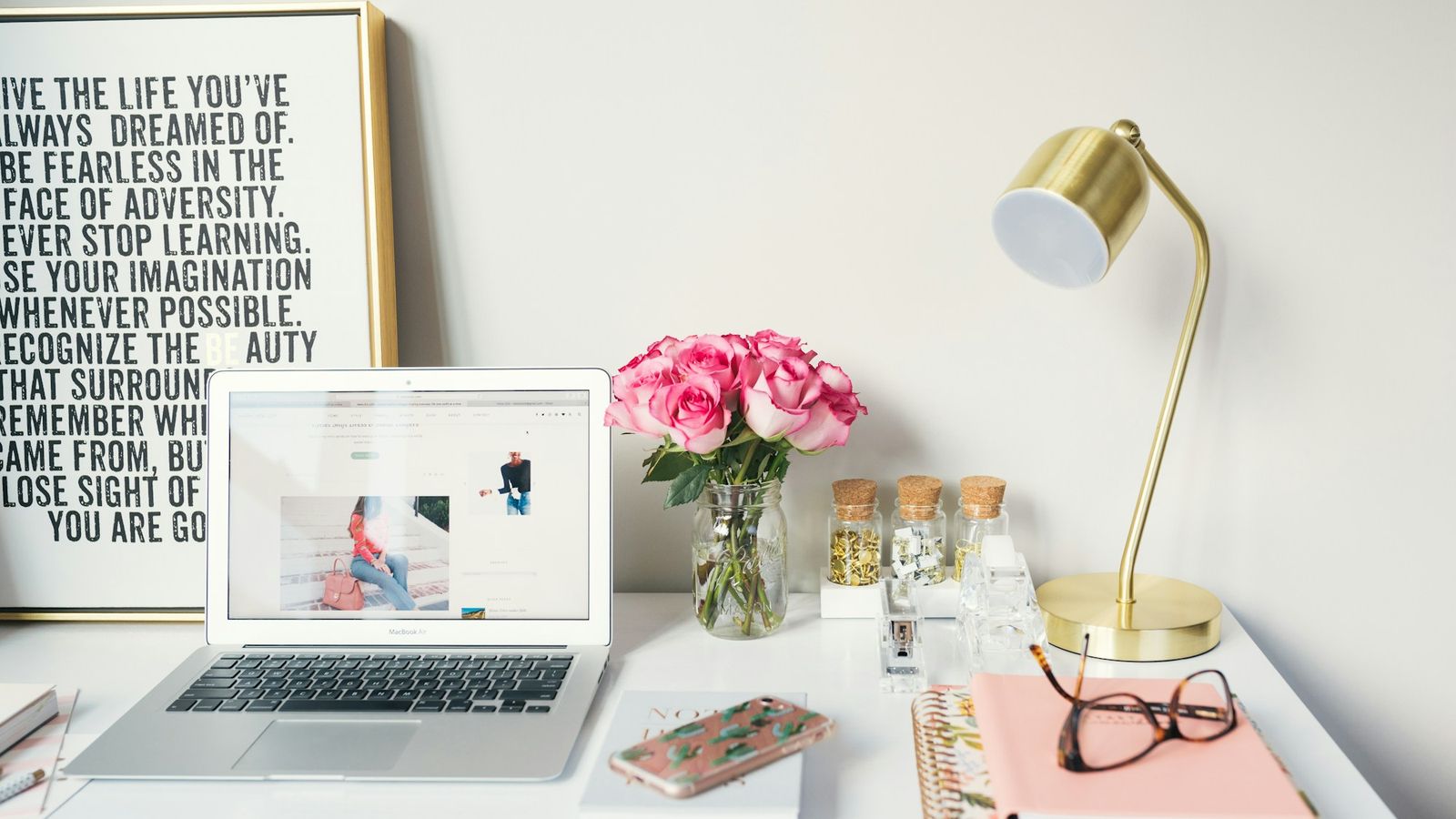 Tidy workstation with laptop, lamp, and notebooks
