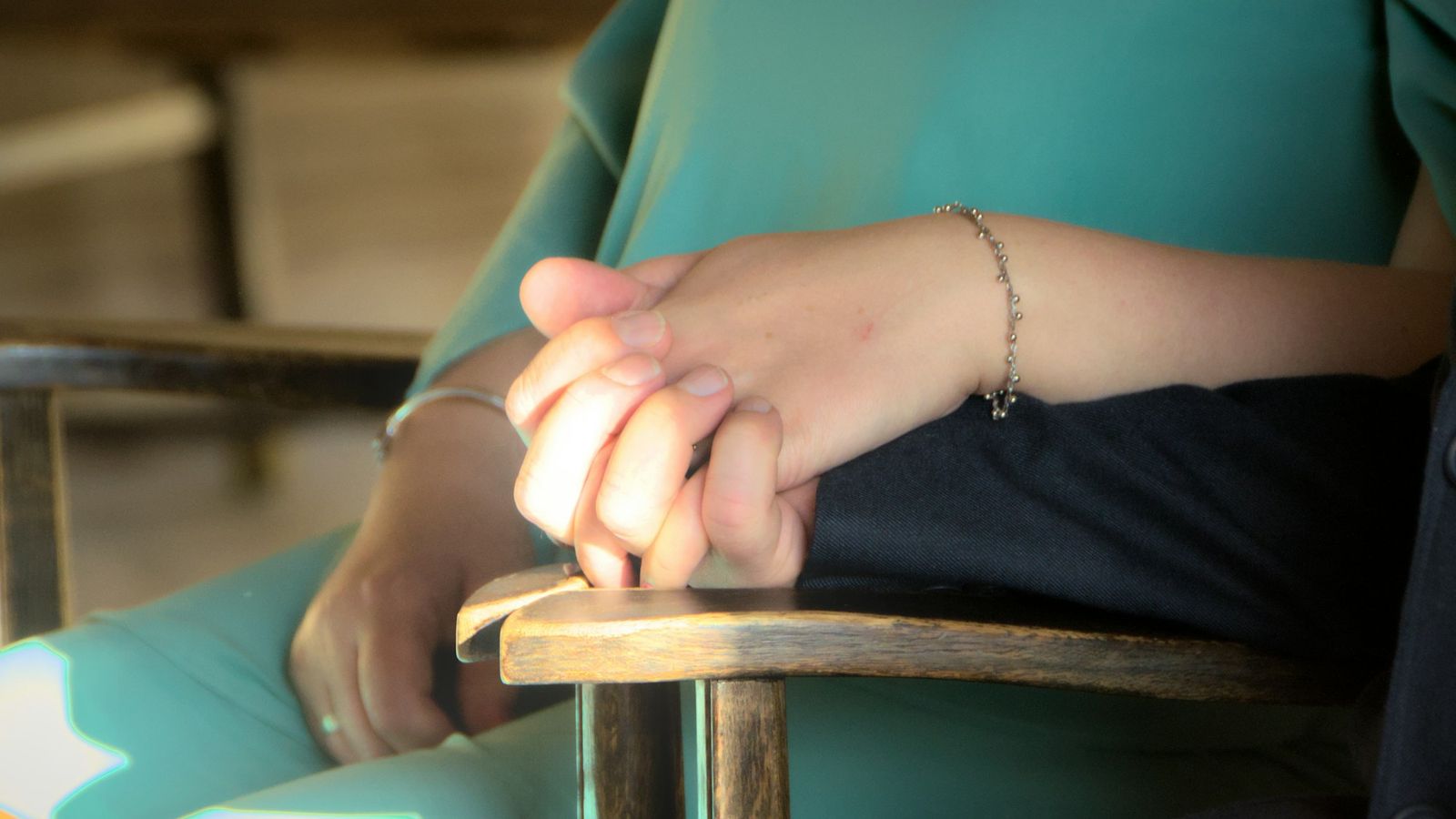 Couple holding hands closely in warm light, a quiet moment of support