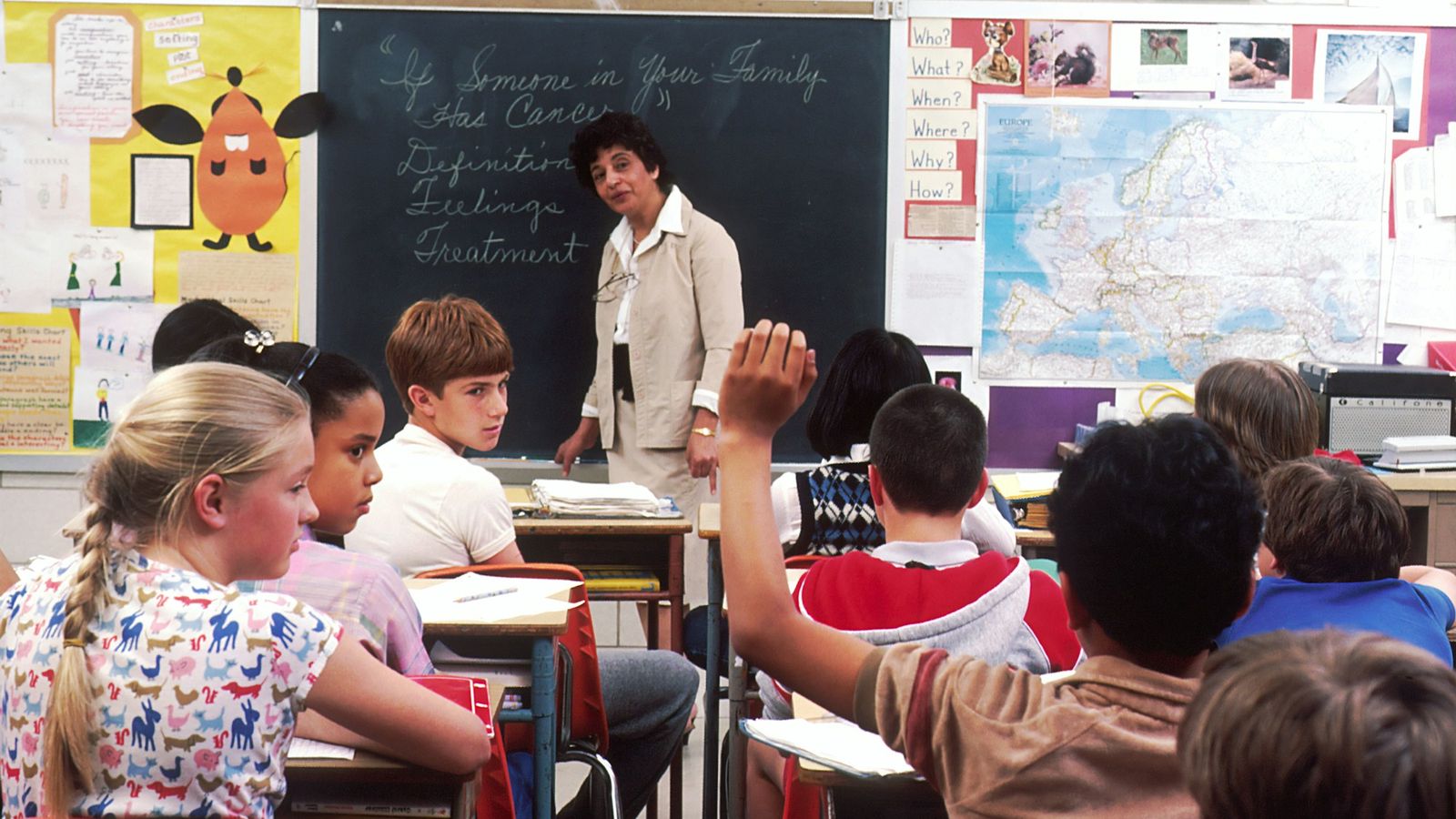 Teacher talking with students in a bright classroom