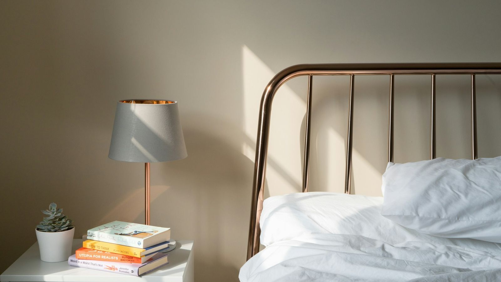 a calm bedroom with a lamp on the nightstand beside the bed