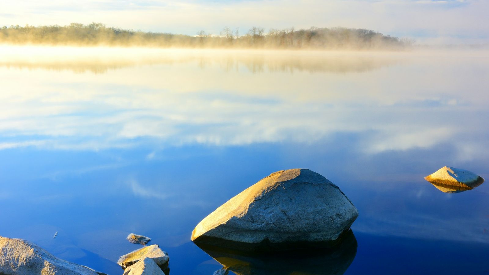Misty sunrise over a calm lake