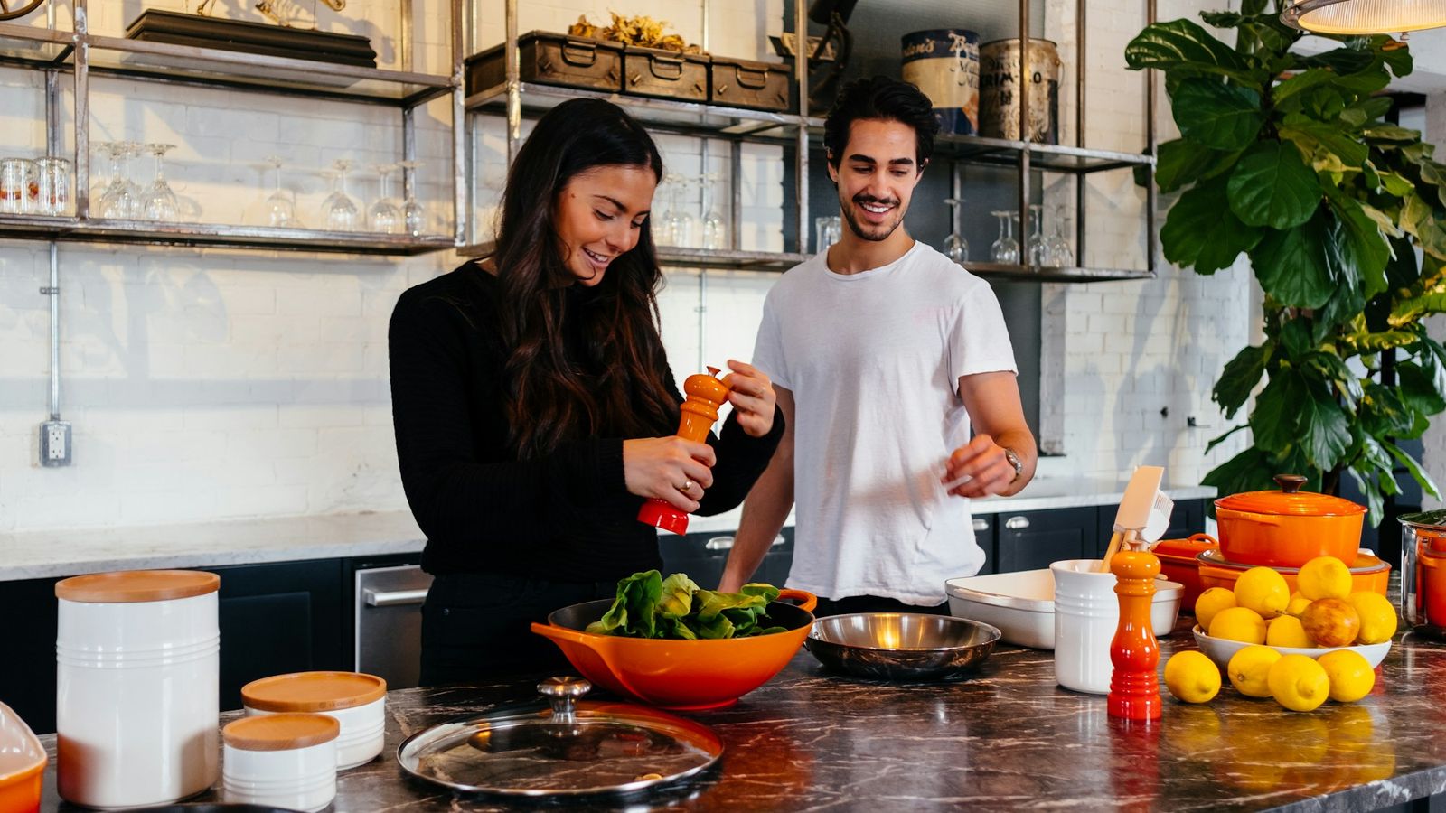 Couple cooking side by side at home