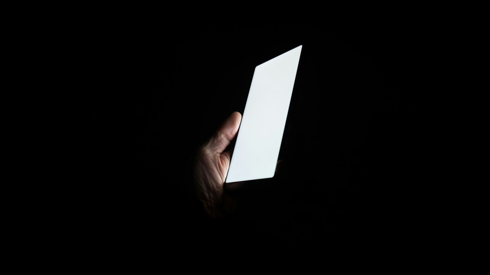 Phone screen glowing in a dark room