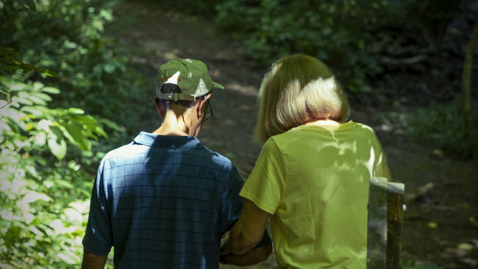 Two people walking slowly together in the woods