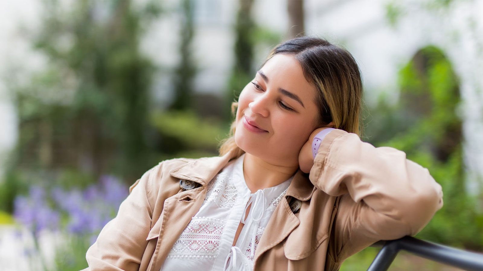 A woman relaxing outdoors with a peaceful smile