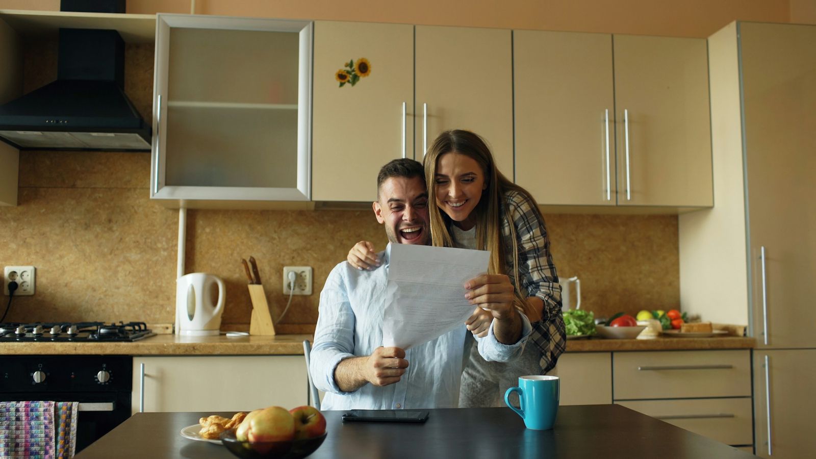A couple reading a document together at their kitchen table