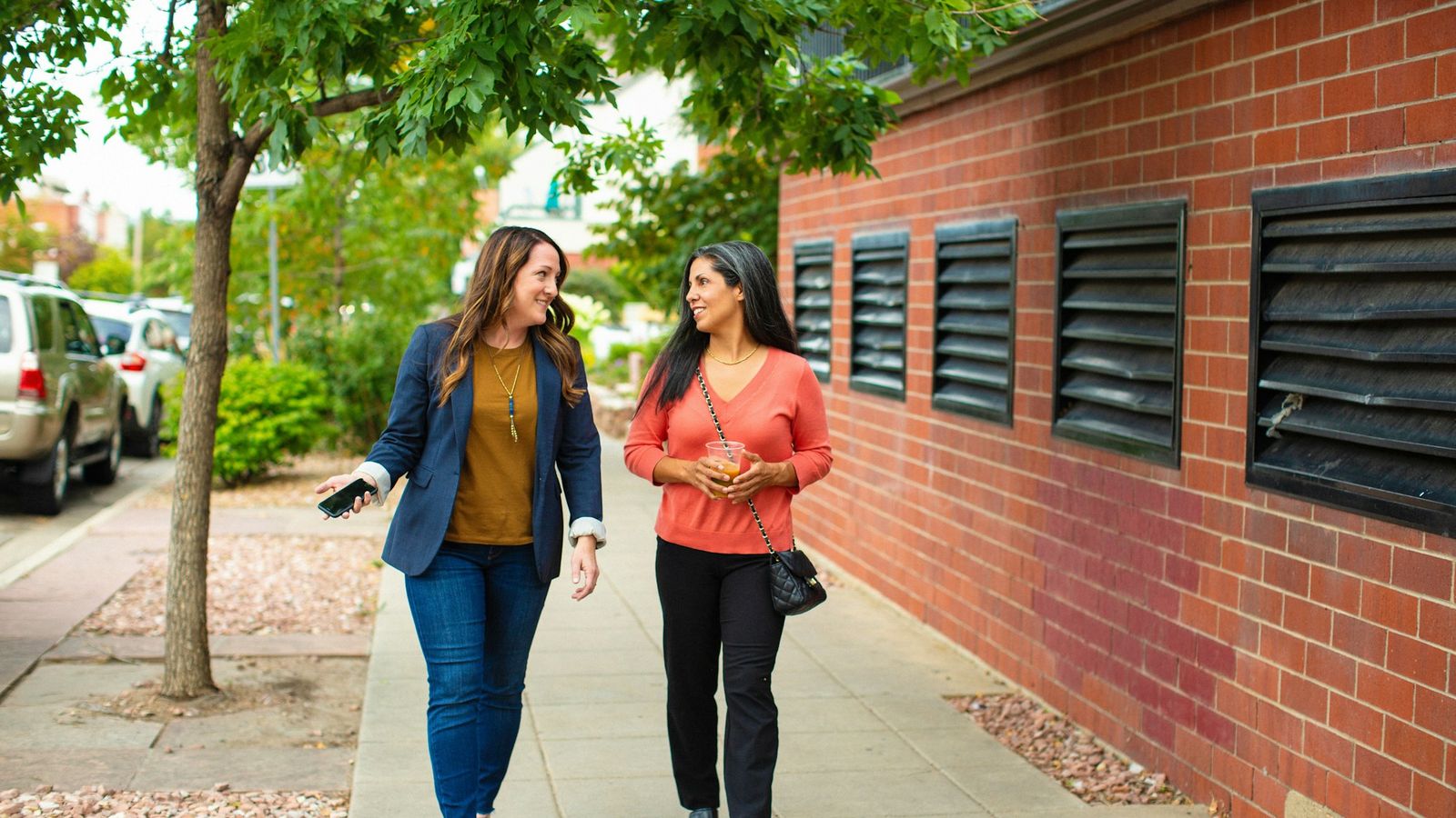 Two friends walking together outdoors having a supportive conversation
