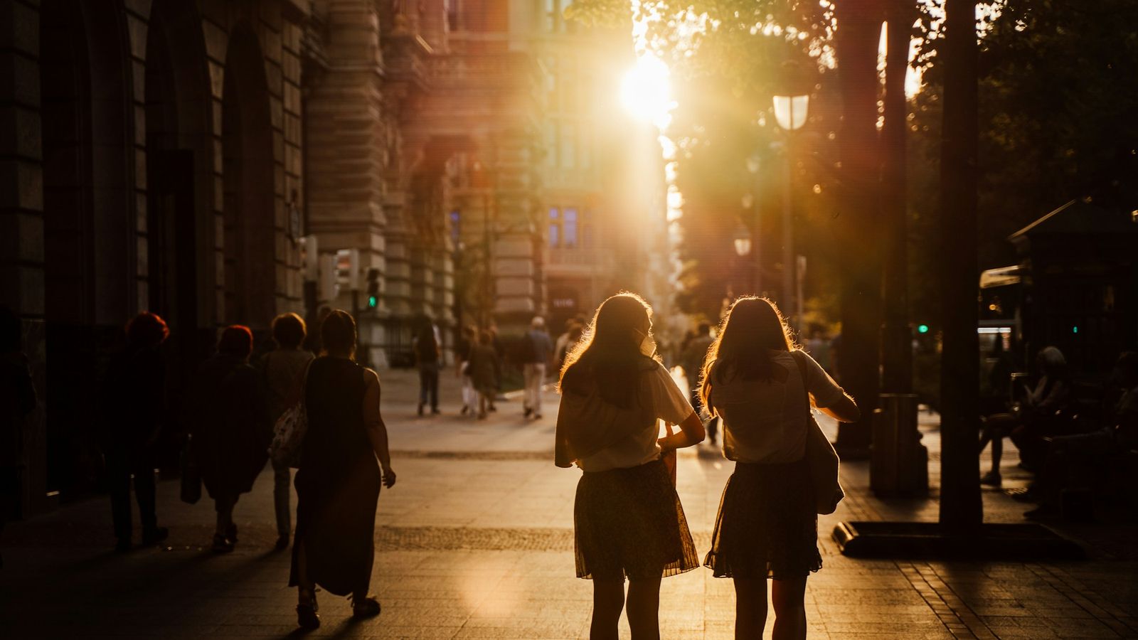 a couple walking through the city together at sunrise