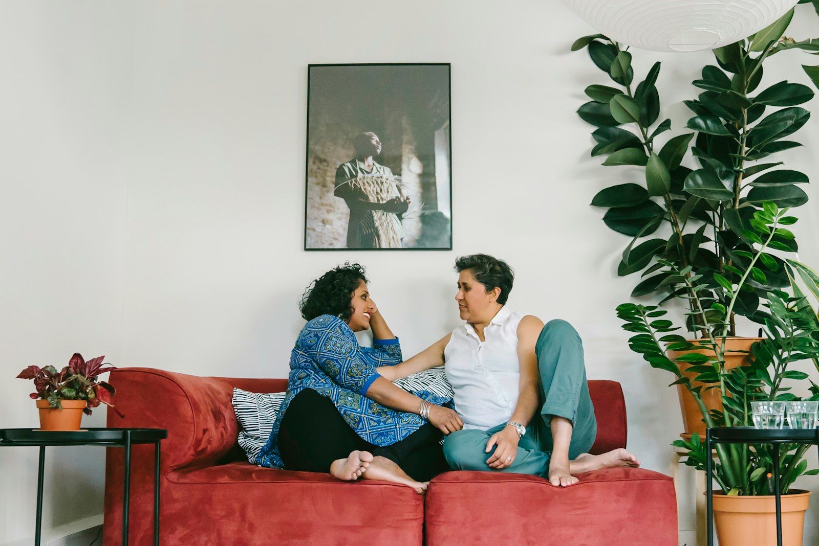 Couple sitting close together on a couch at home, talking and reconnecting