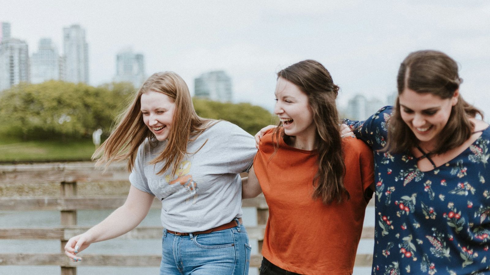 Three teens walking together on a boardwalk