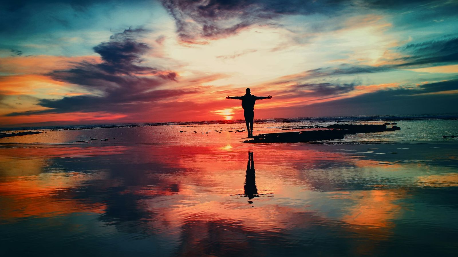 Person greeting the sunrise with open arms
