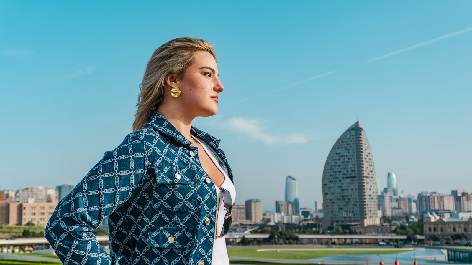 a woman standing on a rooftop looking out over the city skyline